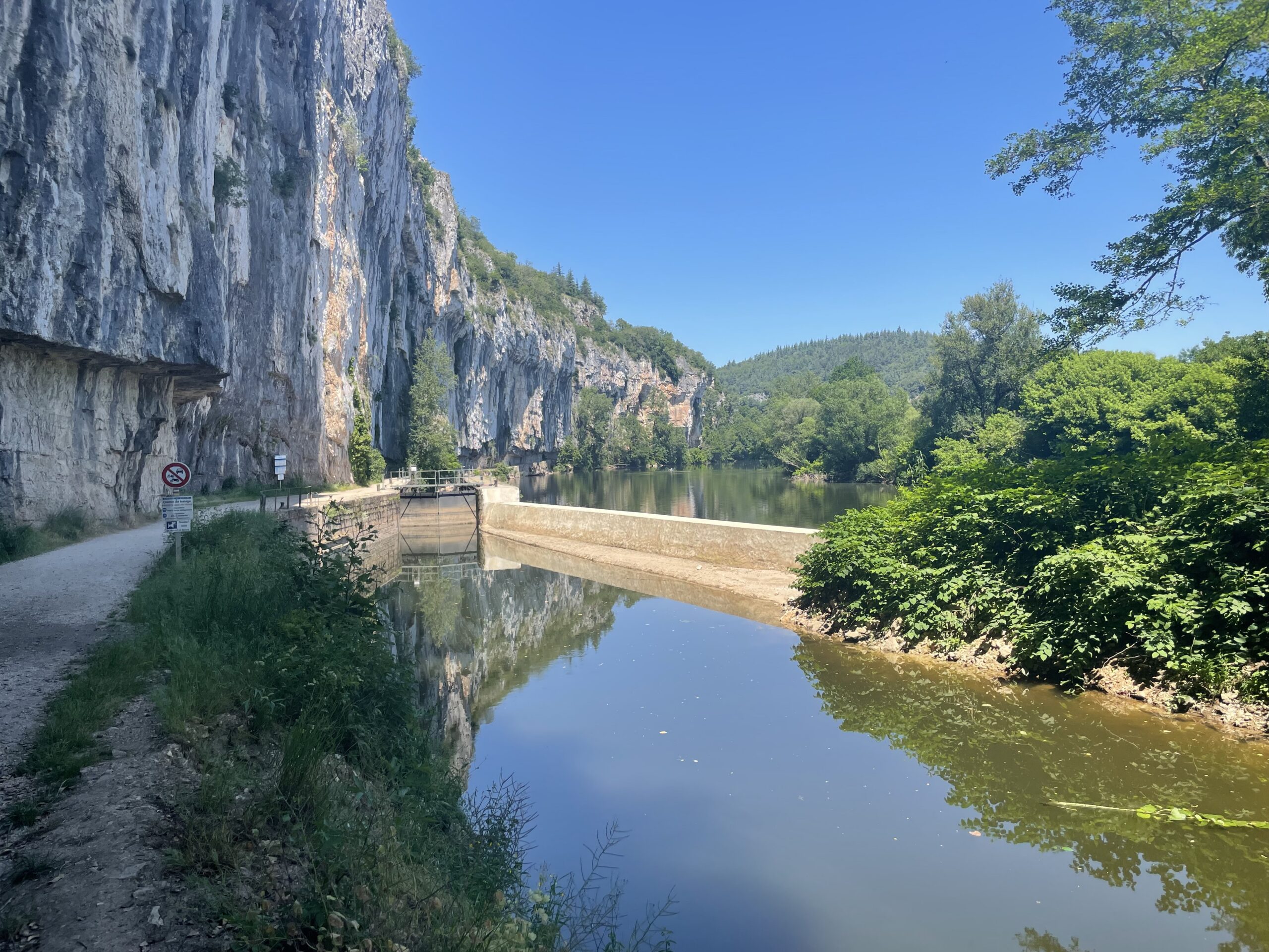 Falaises calcaires au-dessus du Lot, avec un chemin au bord de l’eau